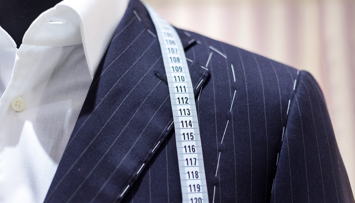 suit on mannequin with tailor’s marks and measuring tape