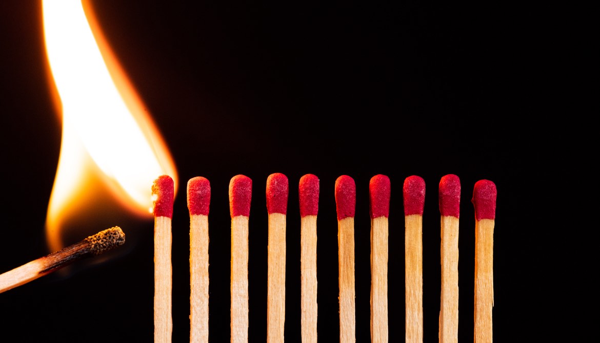 lit match igniting a line of matches