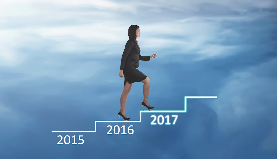 A businesswoman walks up steps past 2015 and 2016 towards 2017