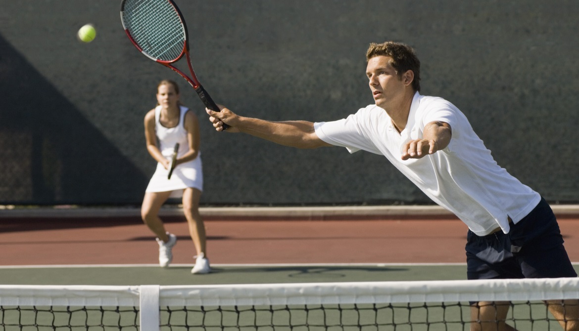 a man and a woman playing doubles tennis