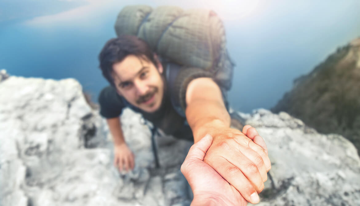 backpacker reaches up to helping hand
