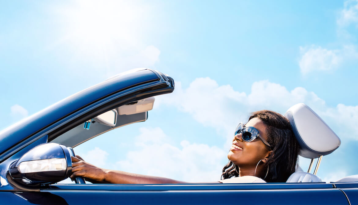 blue convertible car with smiling African American woman driver