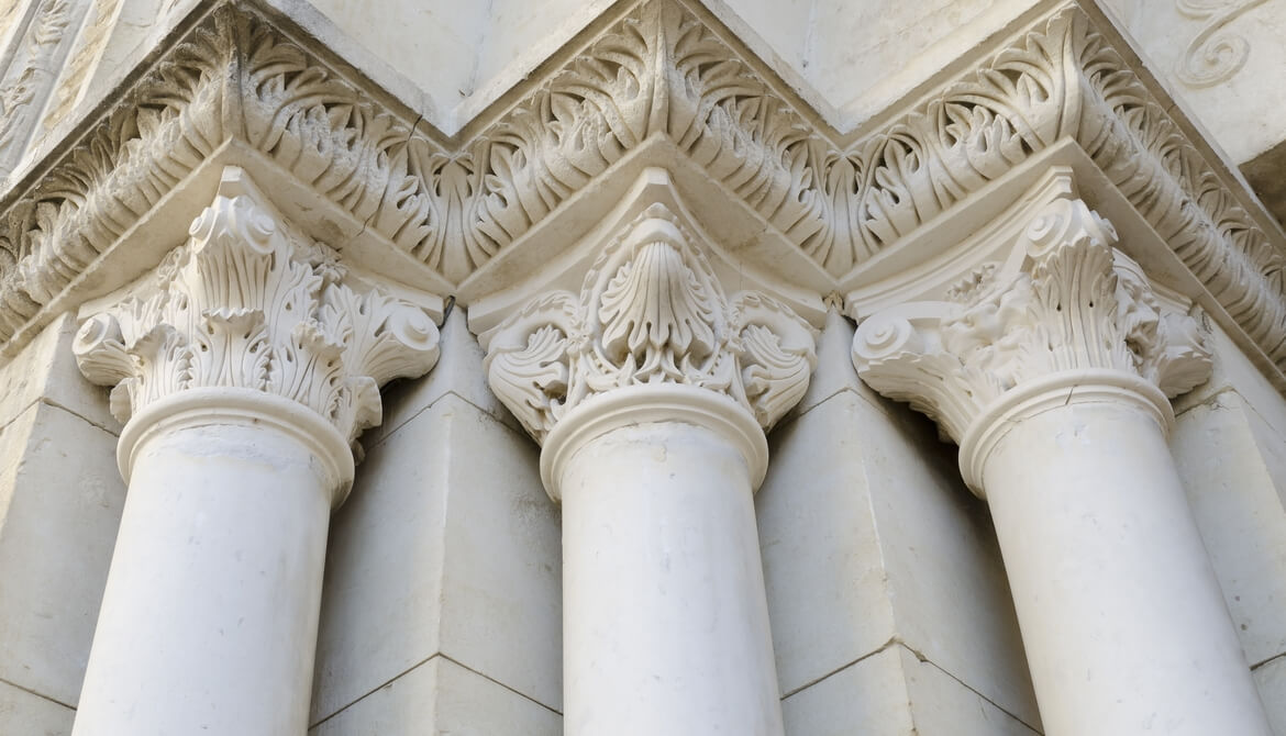 three classical Roman composite columns holding up an ornate frieze