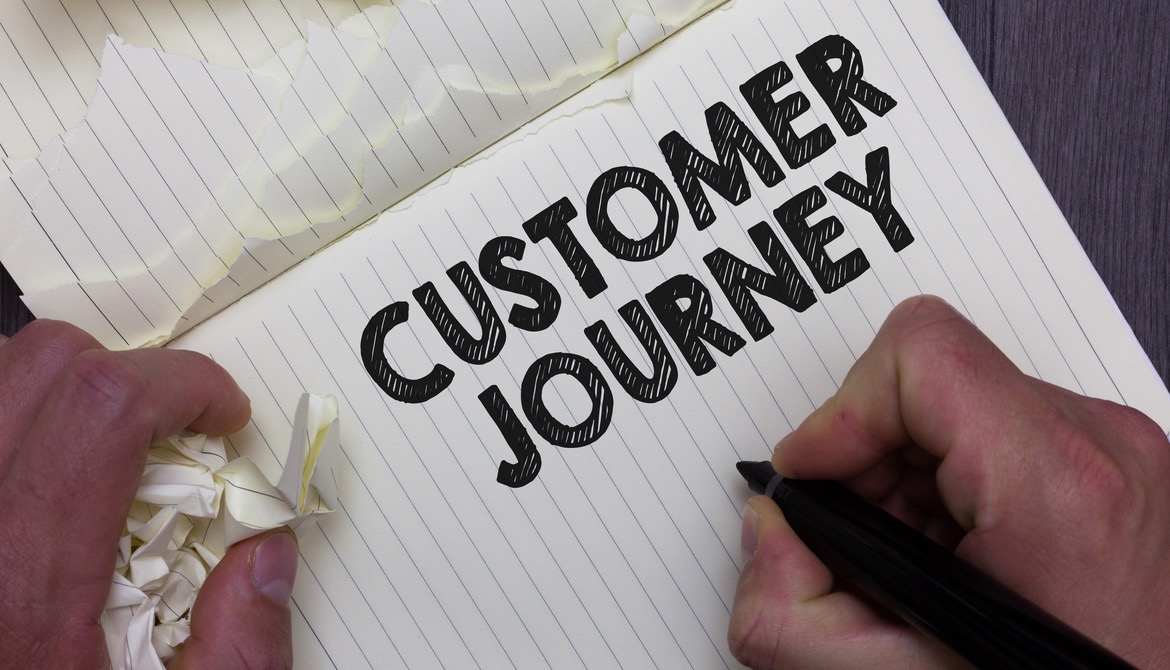 notebook with customer journey written on page