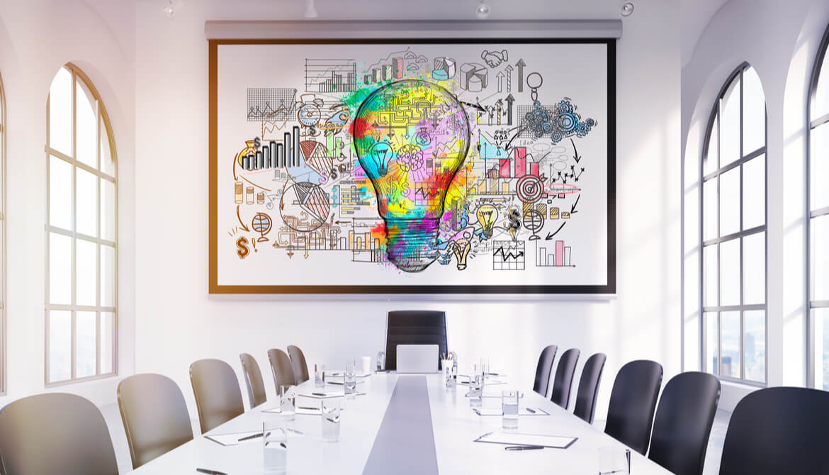large colorful light bulb sketch above the head of a boardroom table