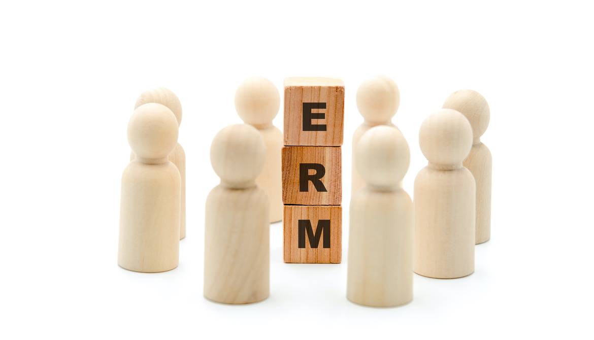  Wooden figures as business team in circle around acronym ERM Enterprise Risk Management