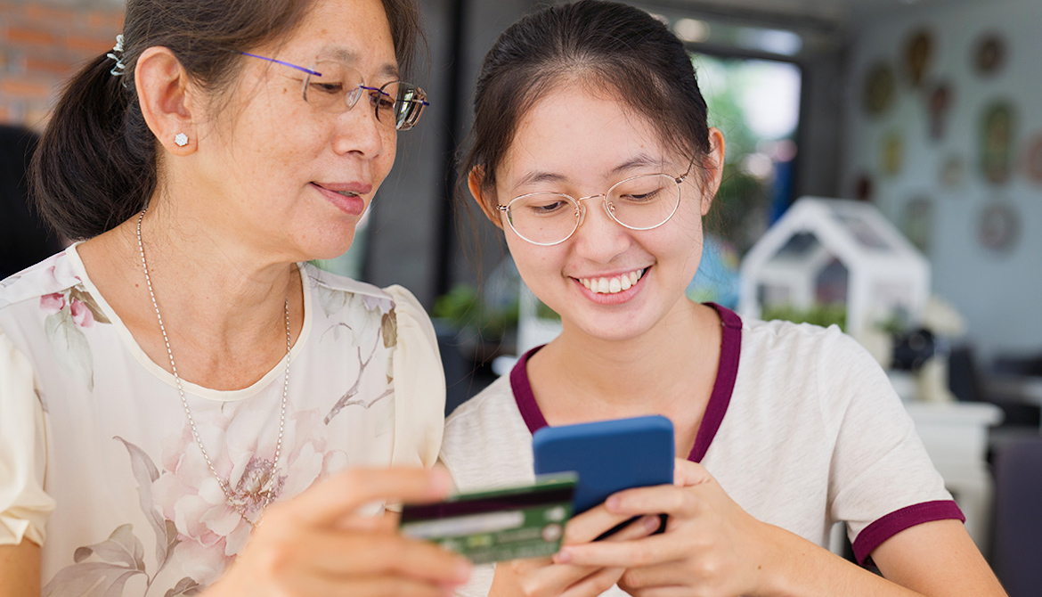 Asian woman and girl use credit card and smartphone