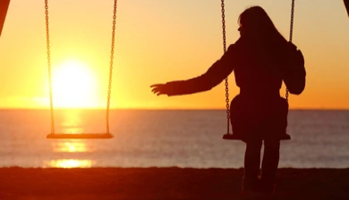 empty swing woman on swing at sunset