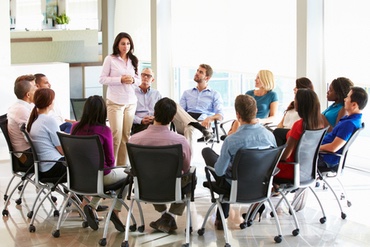 woman standing and speaking confidently in a meeting