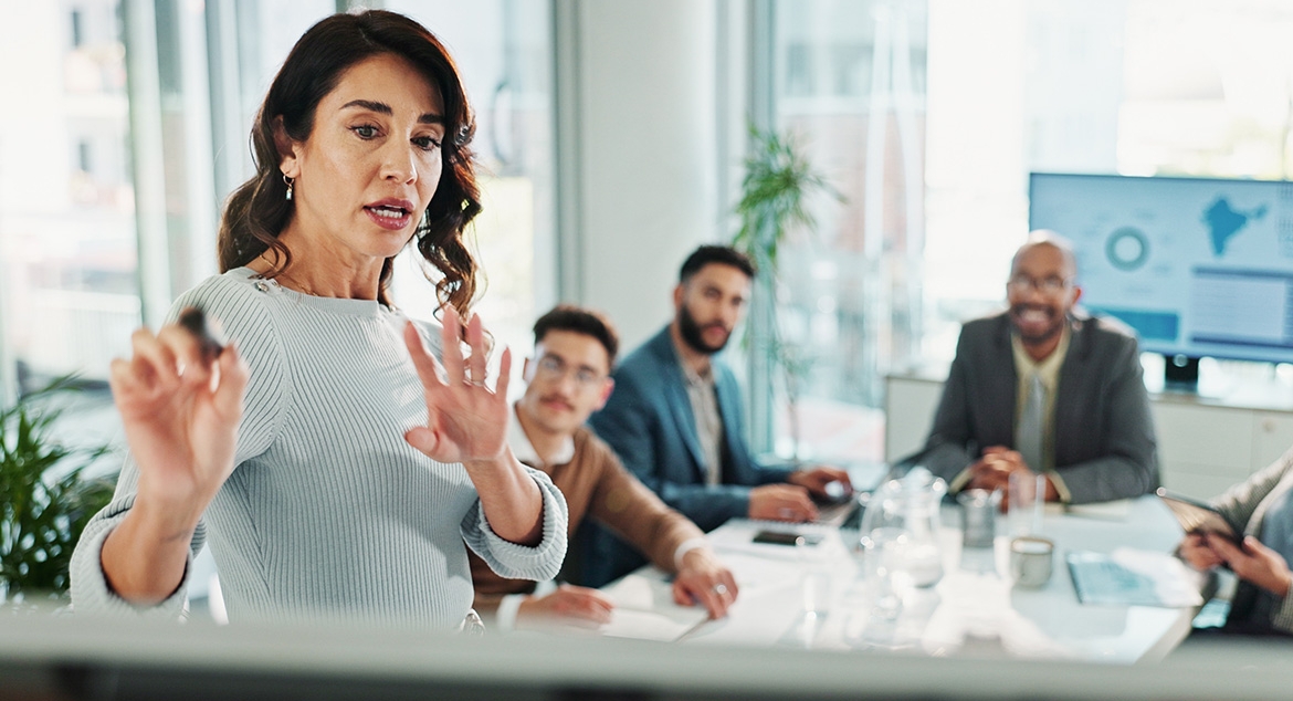 woman explaining to group around table