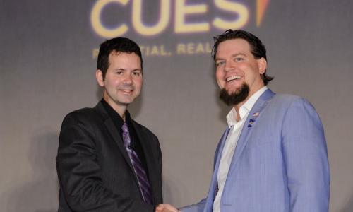 2017 CUES NTCUE winner Geoff Bullock shakes hands with Tim McAlpine of Currency Marketing