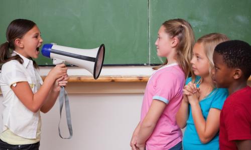 Young girl yelling orders through megaphone at classmates