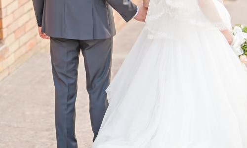 happy bride and groom walking away holding hands