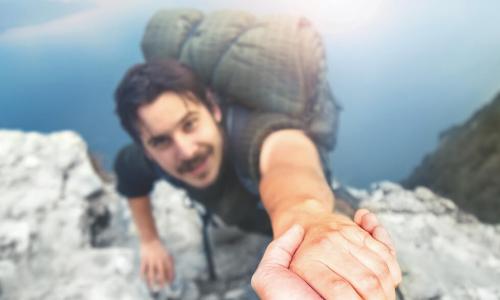 backpacker reaches up to helping hand