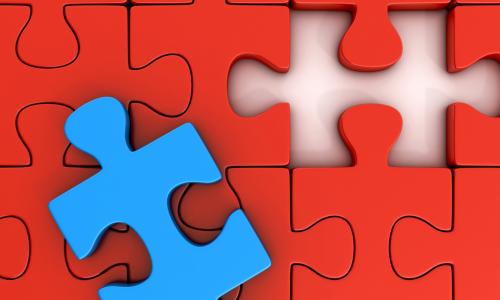 red puzzle pieces forming a perfect gap for the blue puzzle piece on top of them