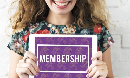 woman holding sign with word membership