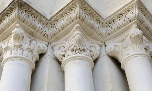 three classical Roman composite columns holding up an ornate frieze