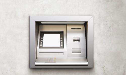 silver ATM on white concrete wall
