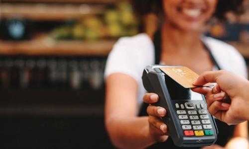 customer taps contactless card on card reader held by clerk