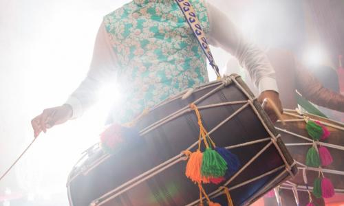drummer carrying colorful traditional drum at festival