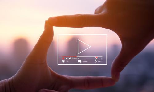 person forming camera frame with fingers with digital illustration of a video player in the frame