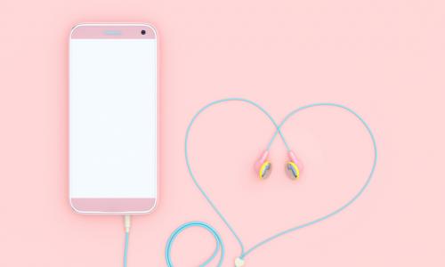 pink smartphone with earbud headphone cord curled into a heart shape