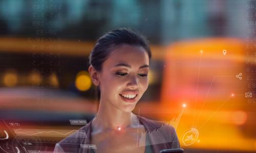 smiling young Asian woman uses app on smartphone while holographic images of technology infrastructure glow around her
