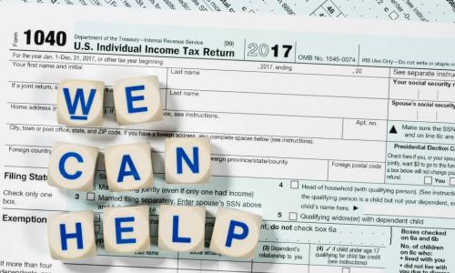 1040 tax form with blocks spelling out we can help