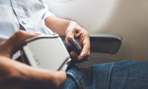 man fastens seat belt on airplane