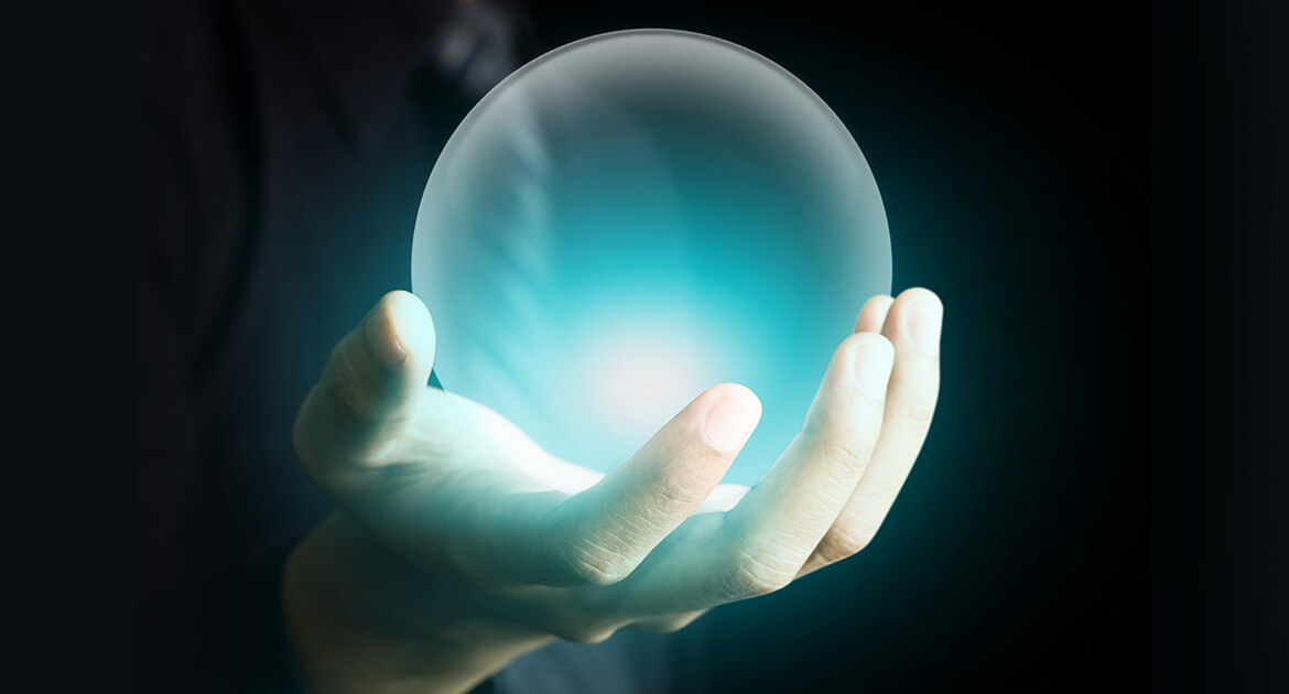 Hand of a business man holding a crystal ball glowing aqua blue