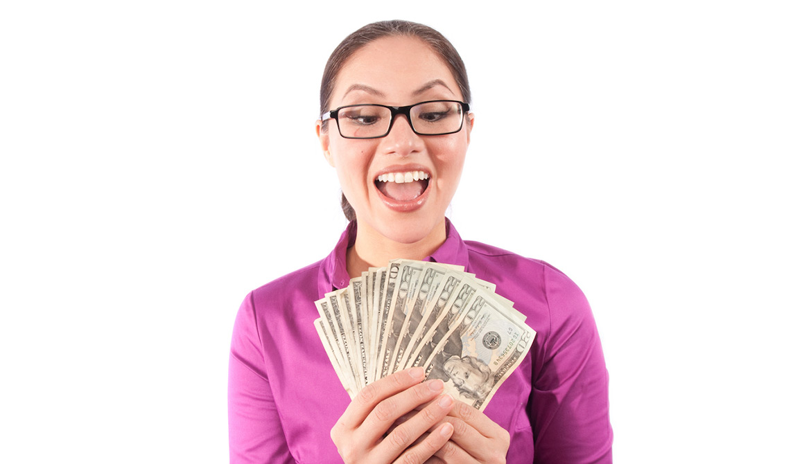 woman in bright pink shirt holding cash