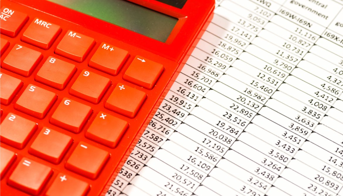 red calculator on top of a spreadsheet