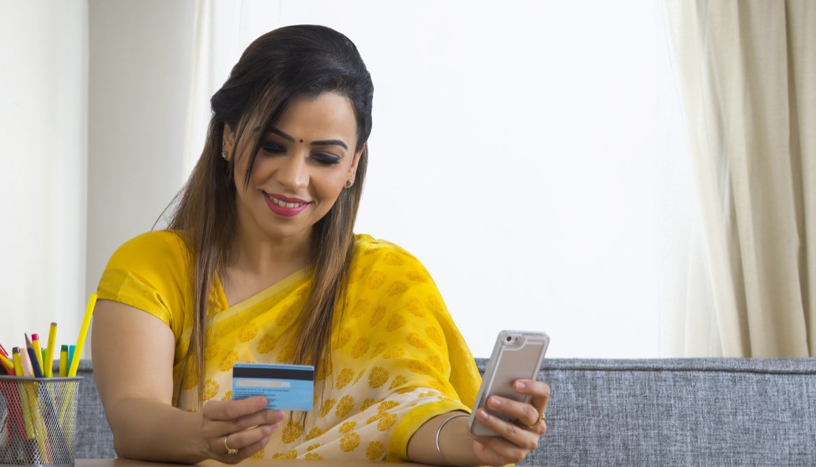 young woman using smart phone to pay 