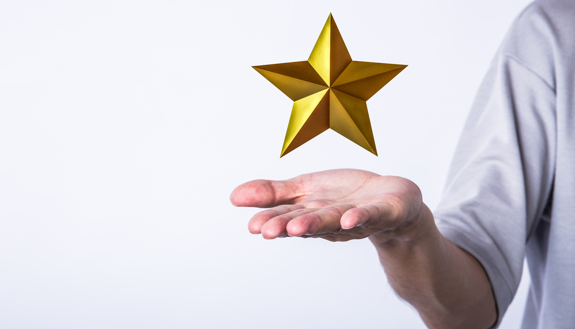 golden star hovering over a man's palm