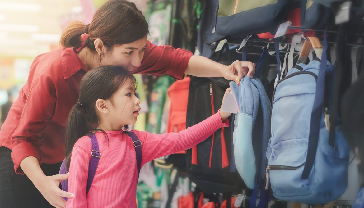 asian mom and daughter shopping for school backpacks