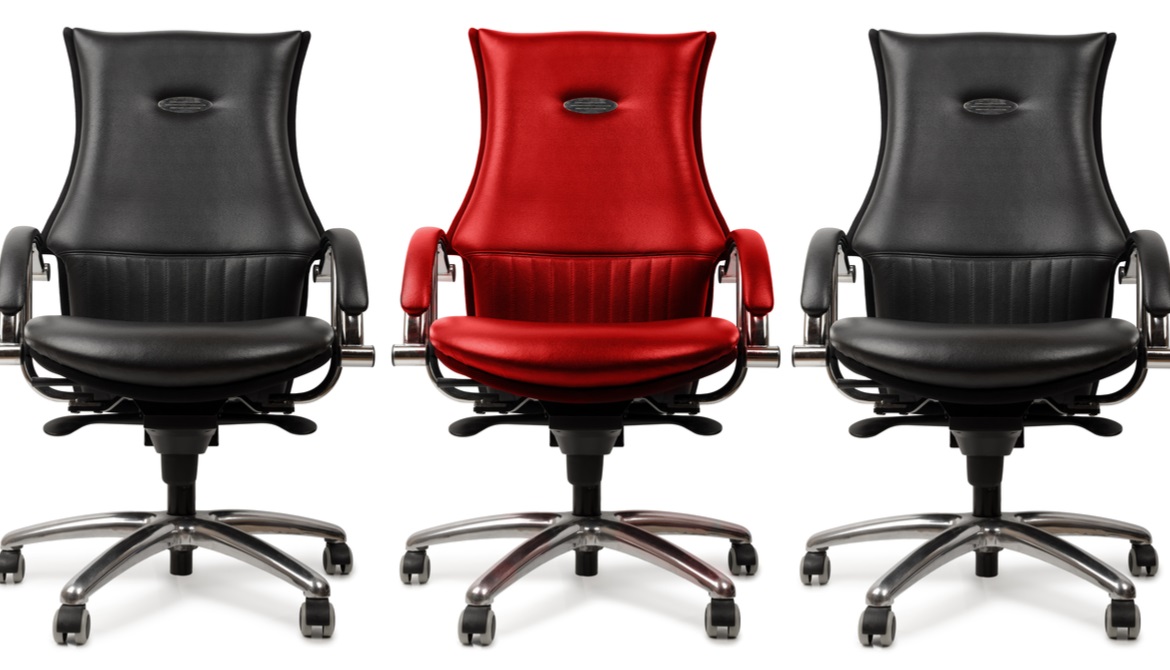 black executive chairs on either side of a red executive chair