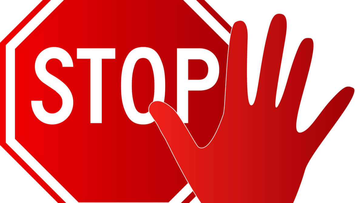 stop sign and red hand held up in a stop motion