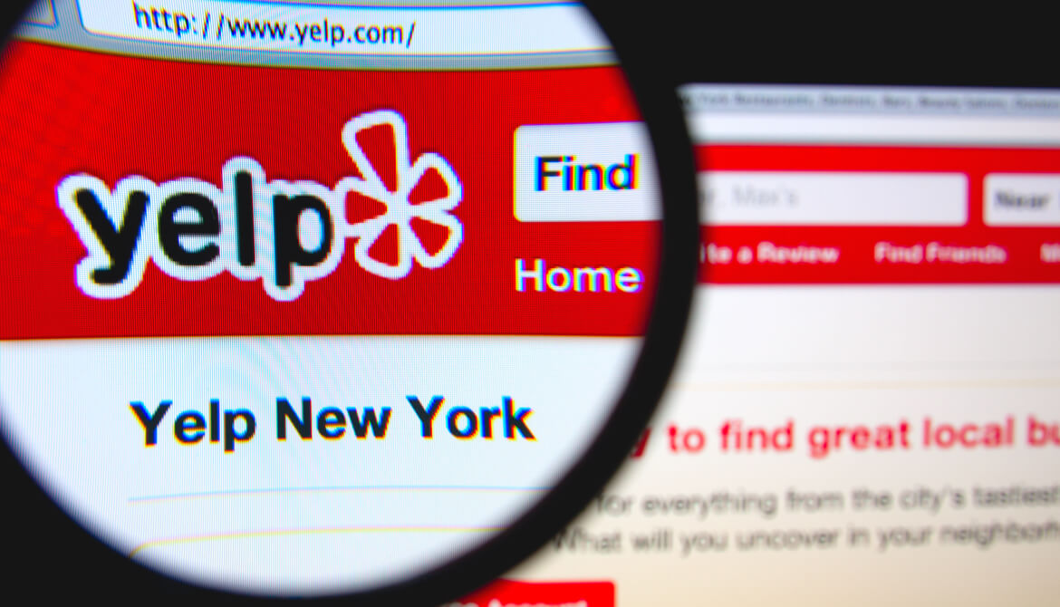 Yelp website being viewed through a magnifying glass