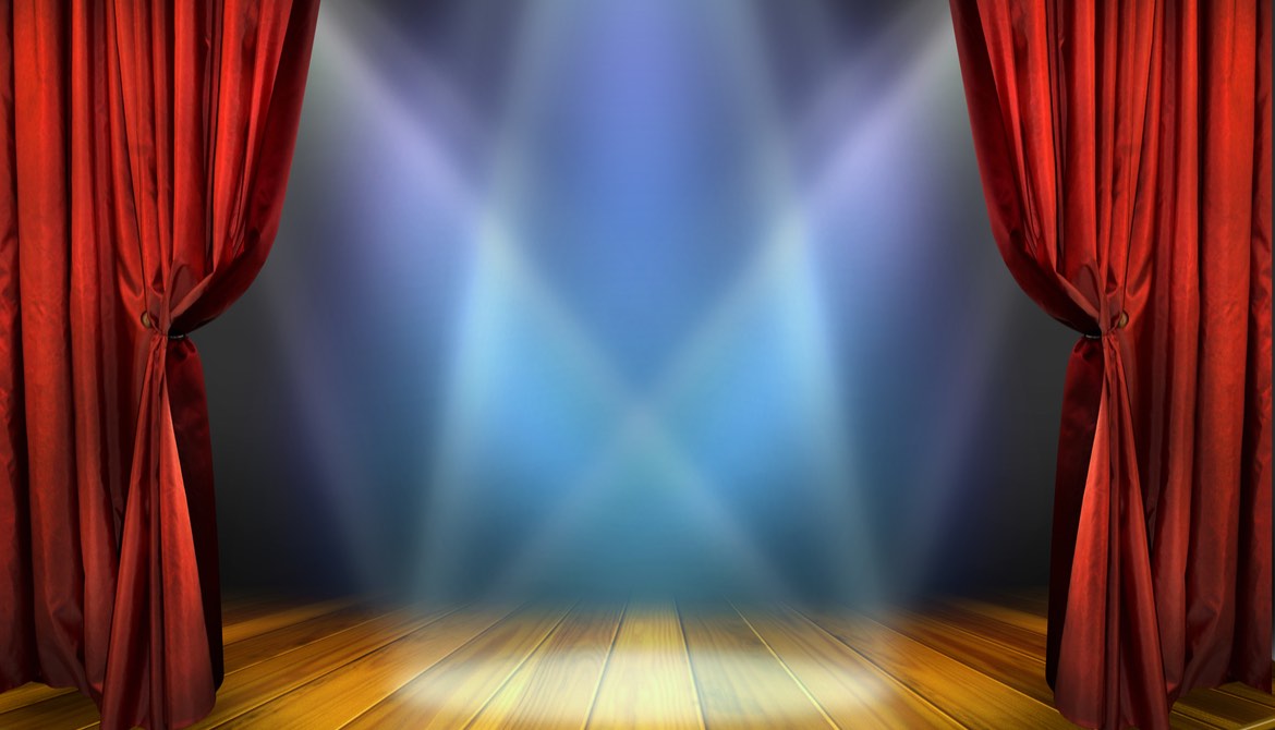 red curtain drawn back to show a wooden stage and spotlights