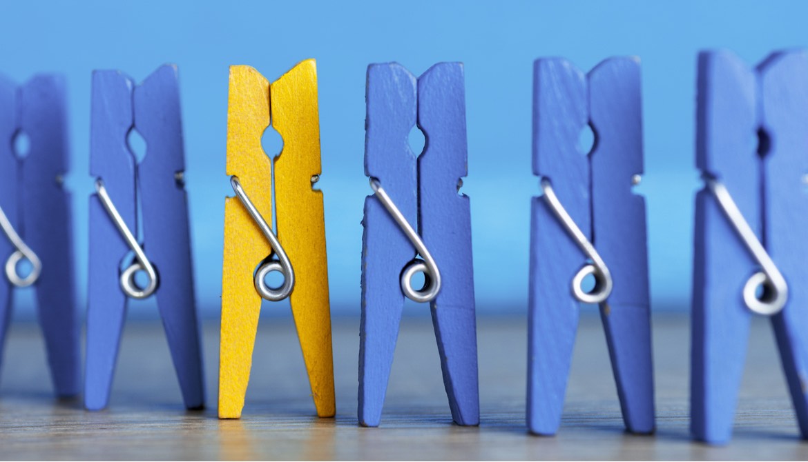 line up of blue clothespins with one yellow one
