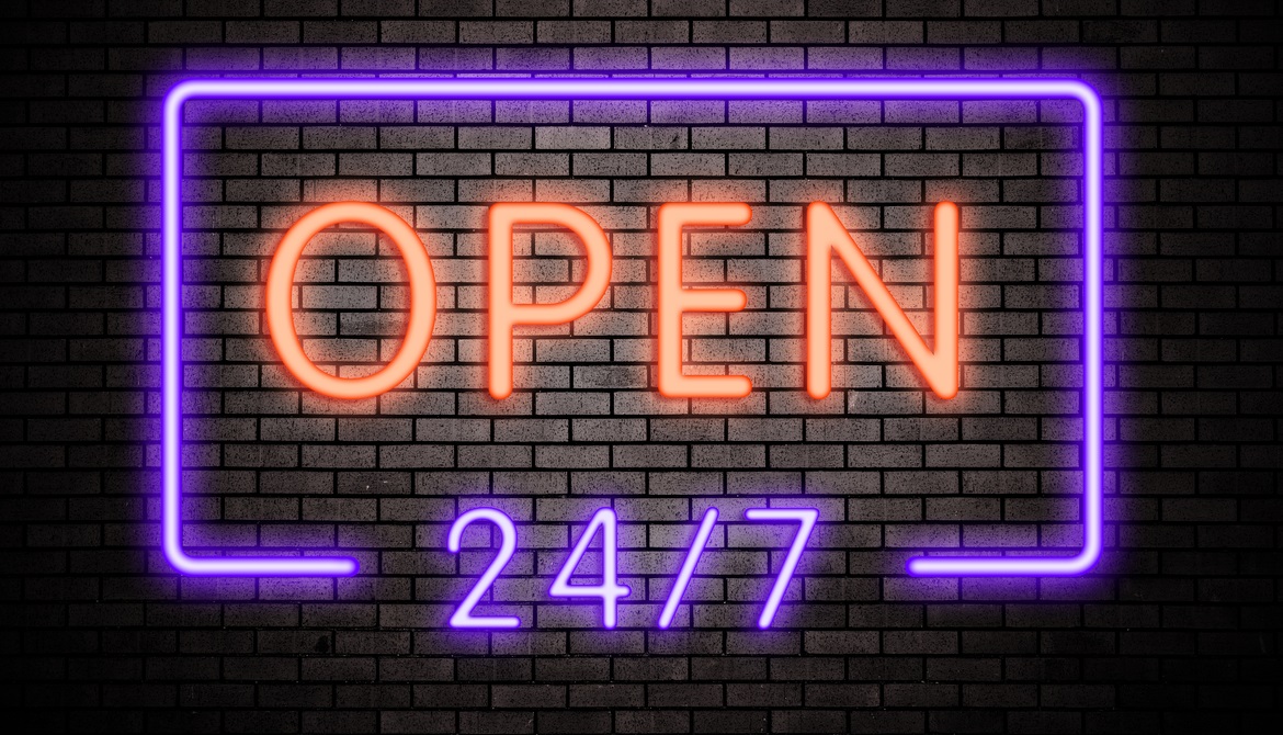 neon sign on a brick wall that reads OPEN 24/7