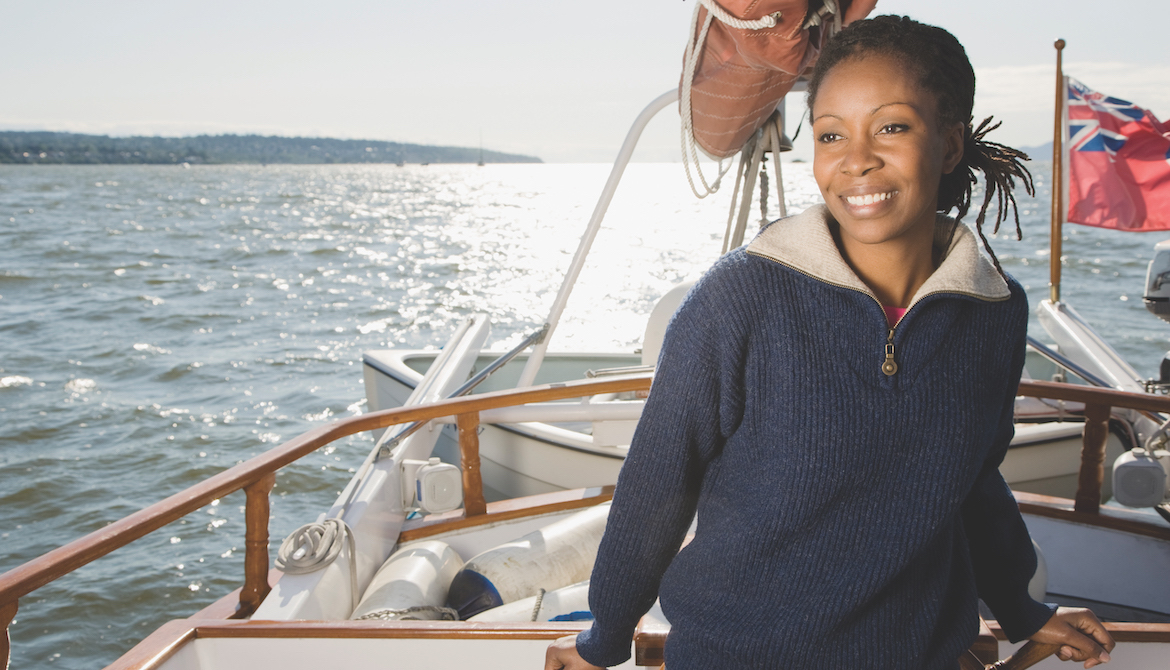 smiling African American woman sailing a sailboat