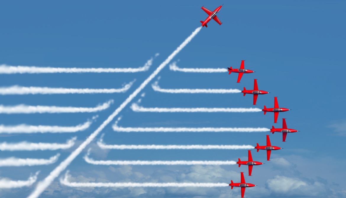red planes flying in a straight formation with jet streams behind with one plane cutting through on a diagonal