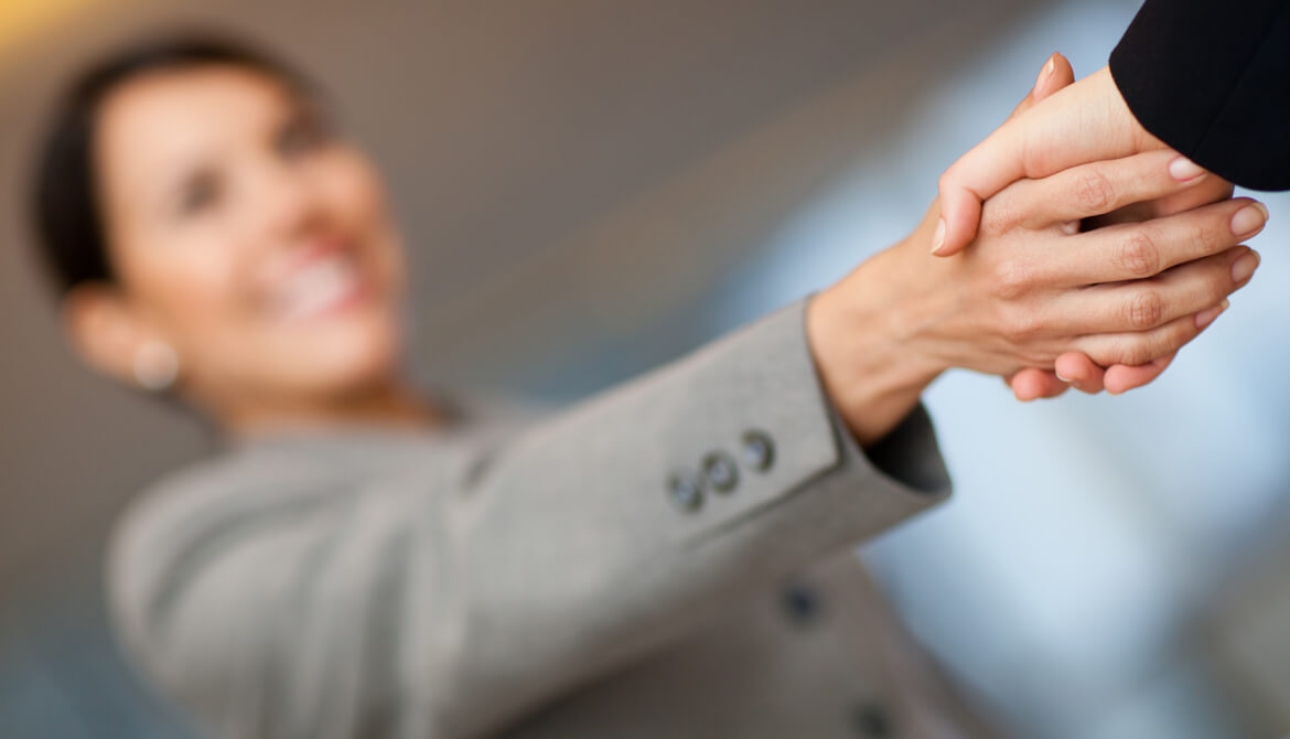 smiling businesswoman greeting a member with a handshake