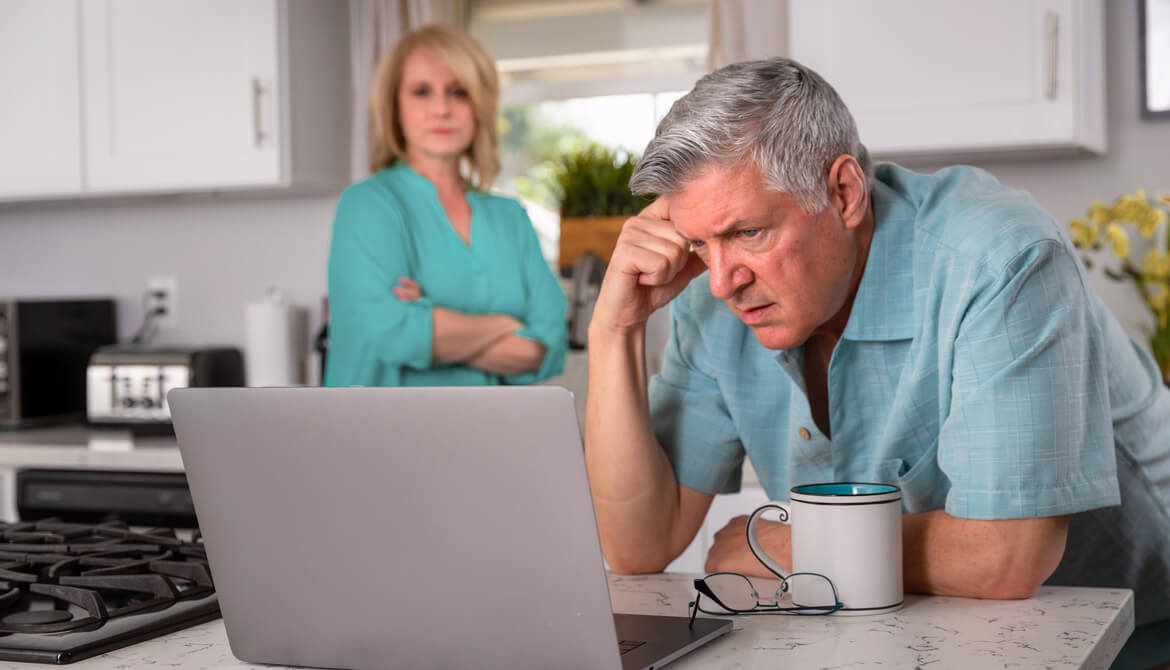 senior couple kitchen laptop financial concerns