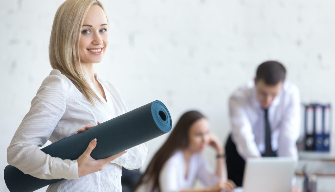 business woman carries yoga mat in the office