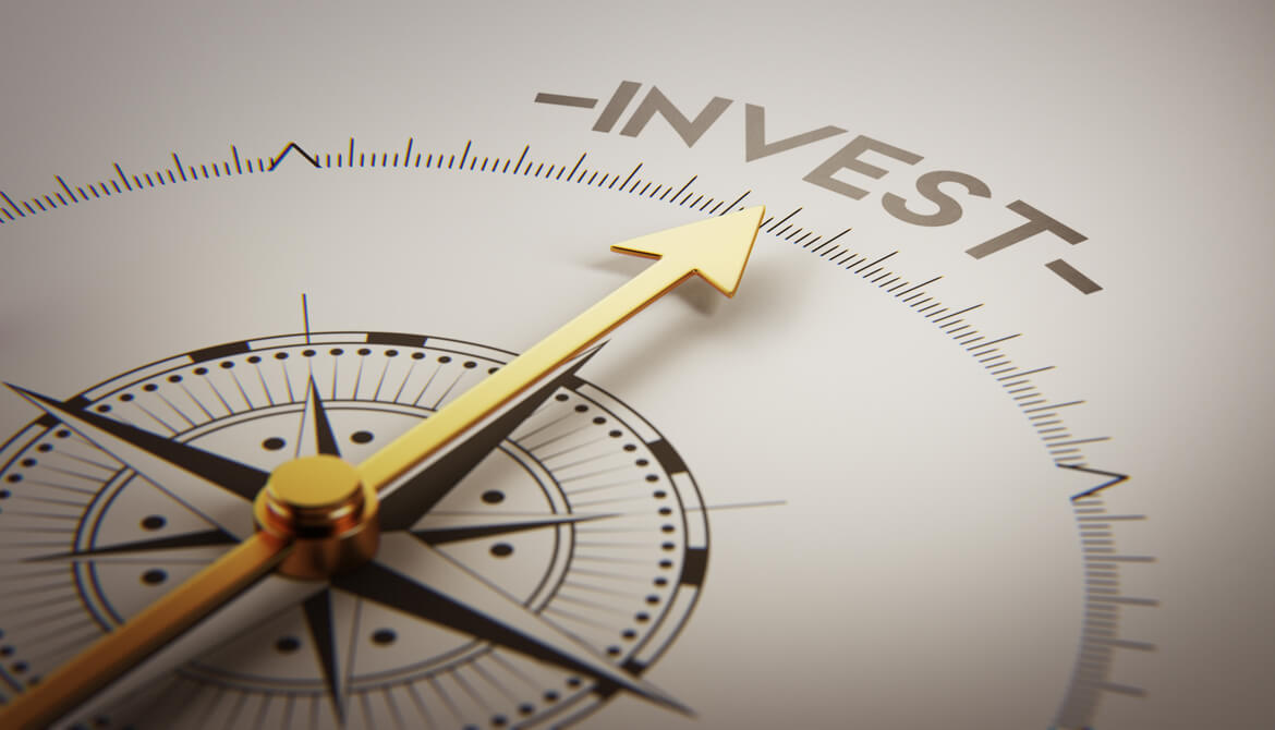 golden arrow on a compass points to the word invest