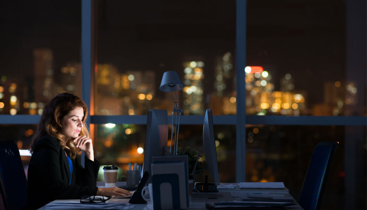 businesswoman leader works alone in dark office at night