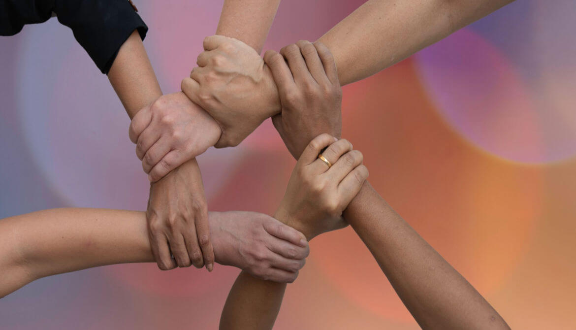diverse people putting their hands together