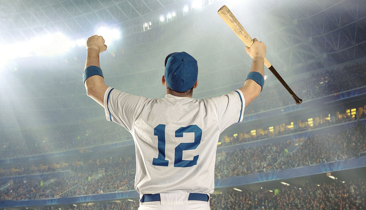number 12 baseball player holding baseball bat pumps fists in victory in front of stadium crowd 
